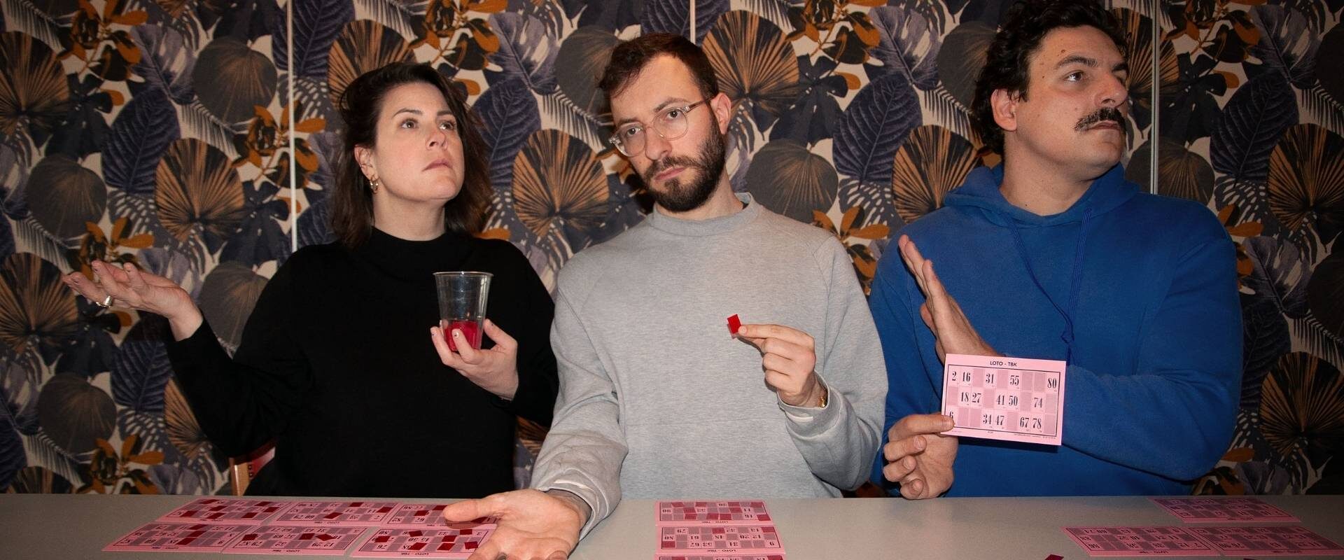 Deux comédiens et une comédienne du spectacle Carton jouent une partie de loto.