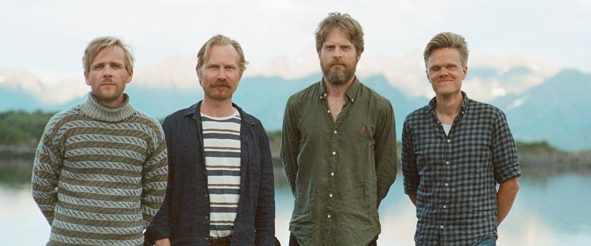 Les quatre musiciens du Danish String Quartet posent devant des paysages scandinaves.