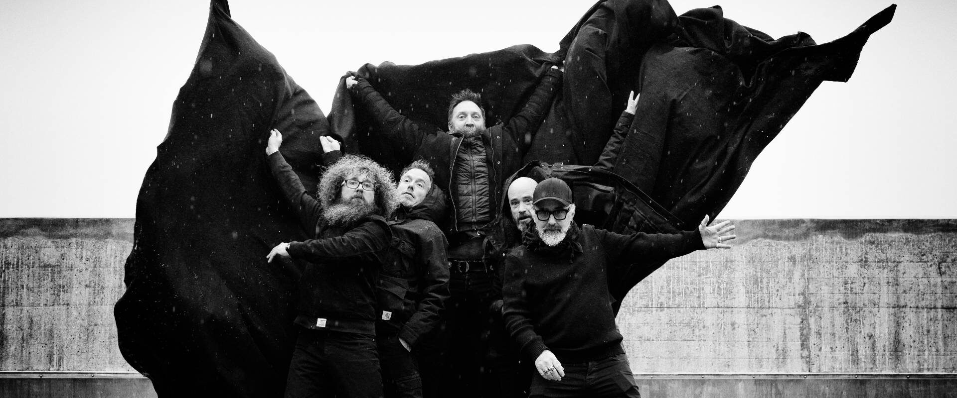 Les cinq comédiens du spectacle Dracula posent en costume avec de grandes capes de vampires.