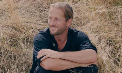 L'auteur Blaise Hofman pose dans un champ pour son spectacle Faire paysan qui parle de nos liens à la terre.