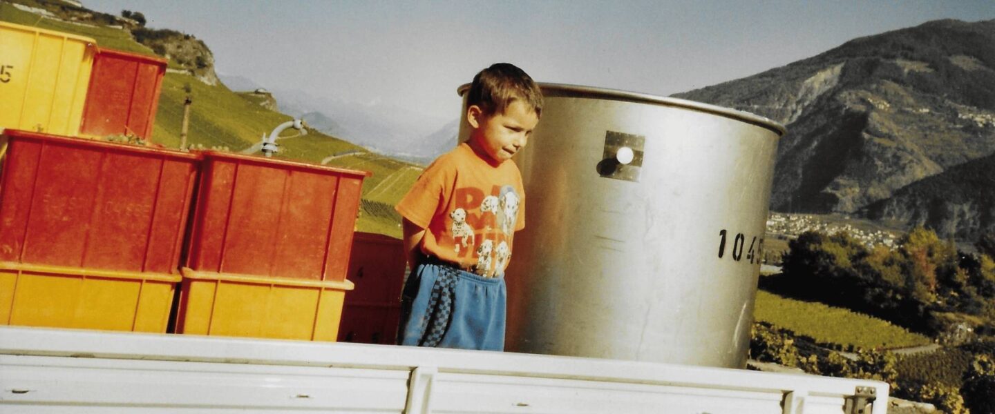 Emeric Cheseaux pose enfant devant les montagnes et entre les machines pour son spectacle La révérence.