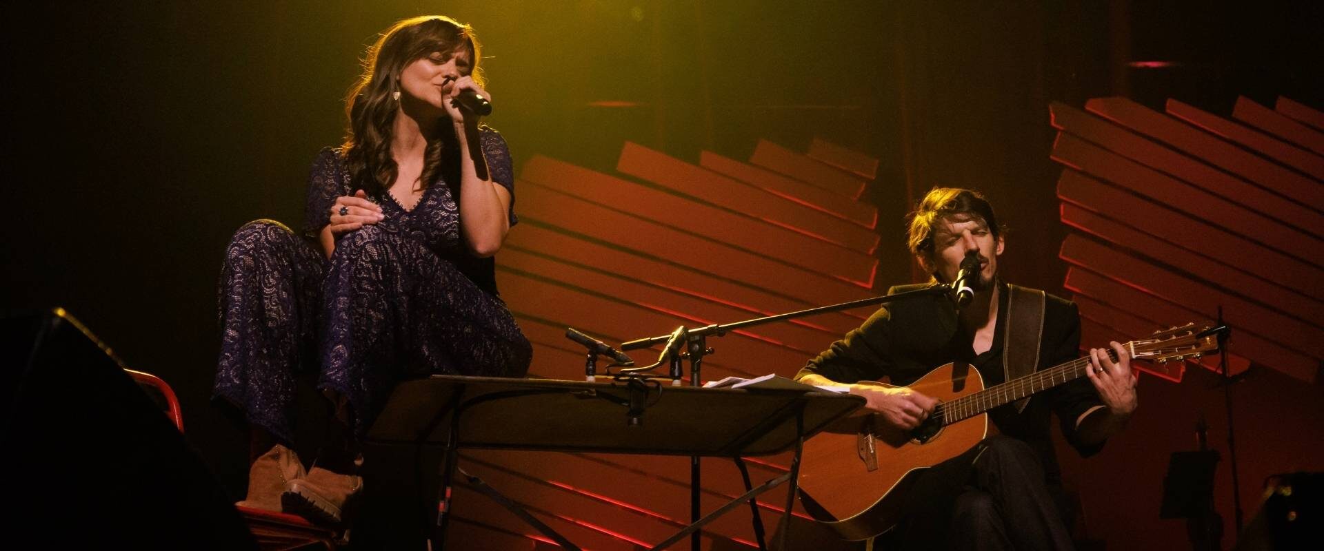 Alizé Oswald et Xavier Michel du duo Aliose chantent et jouent de la guitare sur scène les yeux fermés dans un hommage à Maxime Le Forestier.