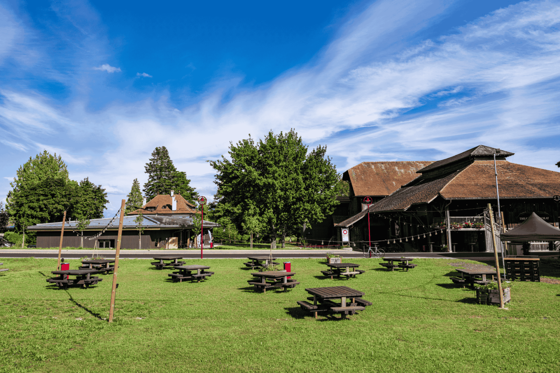 Jardins aux alentours du Théâtre du Jorat avec pelouse et tables extérieures